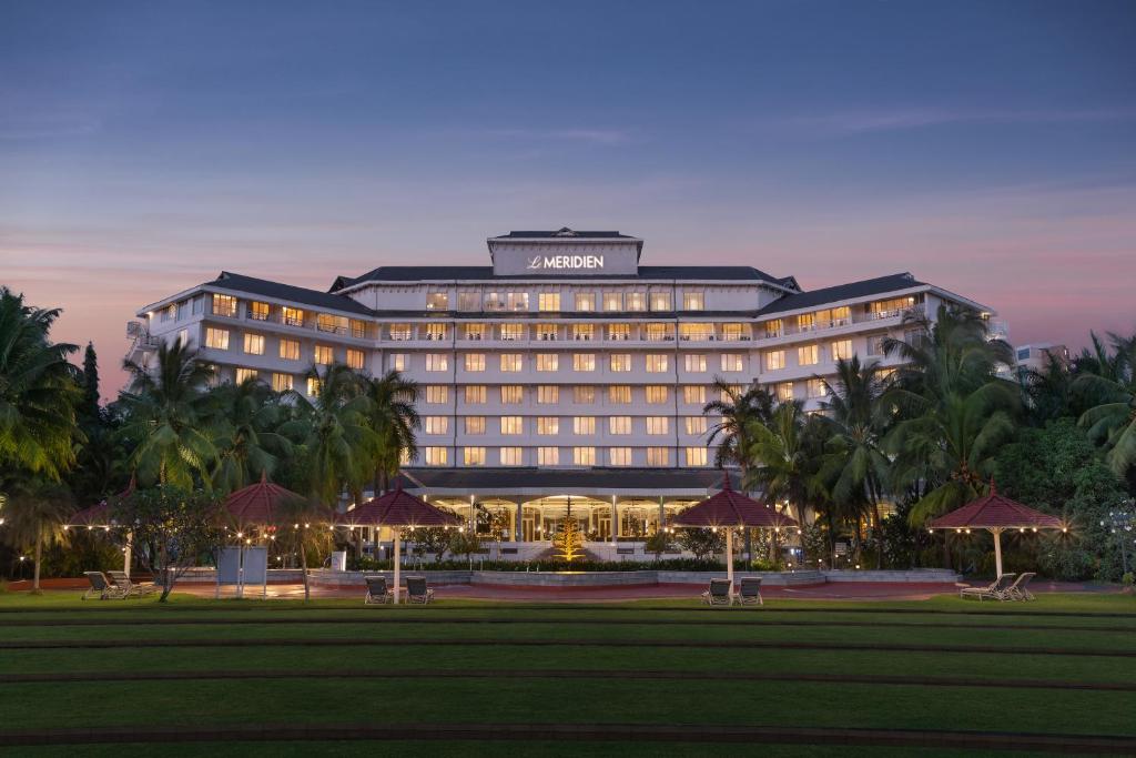 a lit up hotel with palm trees in front of it at Le Meridien Kochi in Cochin