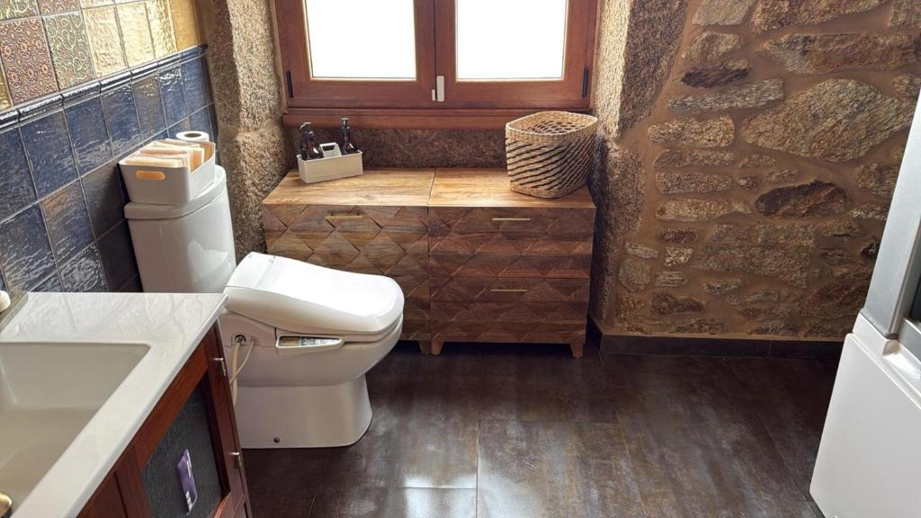 a small bathroom with a toilet and a sink at Villa Careixo in Castro