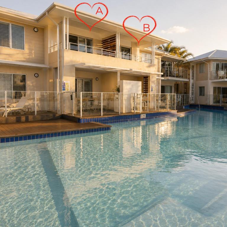 a swimming pool with two hearts on the side of a building at Newly Restyled Resort 2 Bedroom Unit Oaks Pacific Blue in Salamander Bay