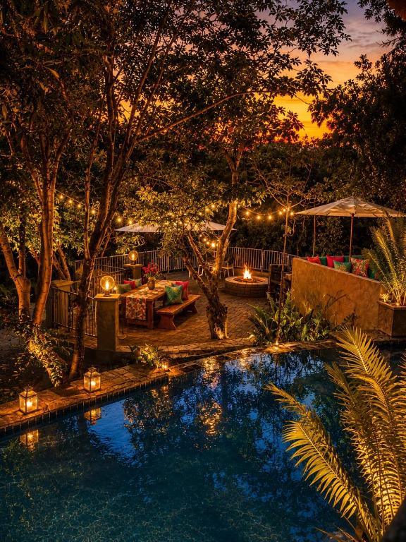 a backyard with a swimming pool at night with lights at Forget me not Selfcatering Apartments in Nelspruit