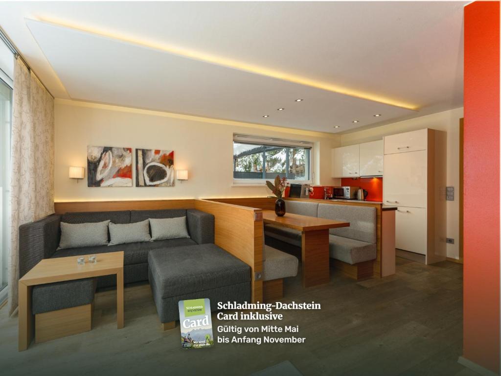 a living room with a couch and a kitchen at Appartementhaus Leeder by Schladming-Appartements in Schladming