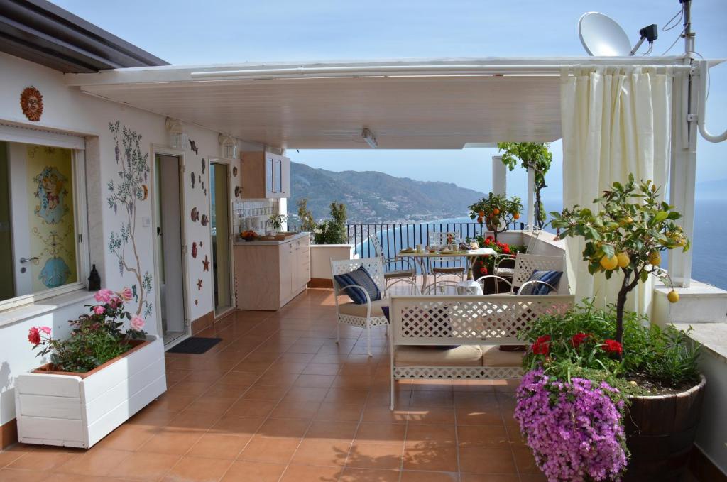 balkon ze stołem i krzesłami oraz widokiem na ocean w obiekcie Apartment L'Attico w Taominie