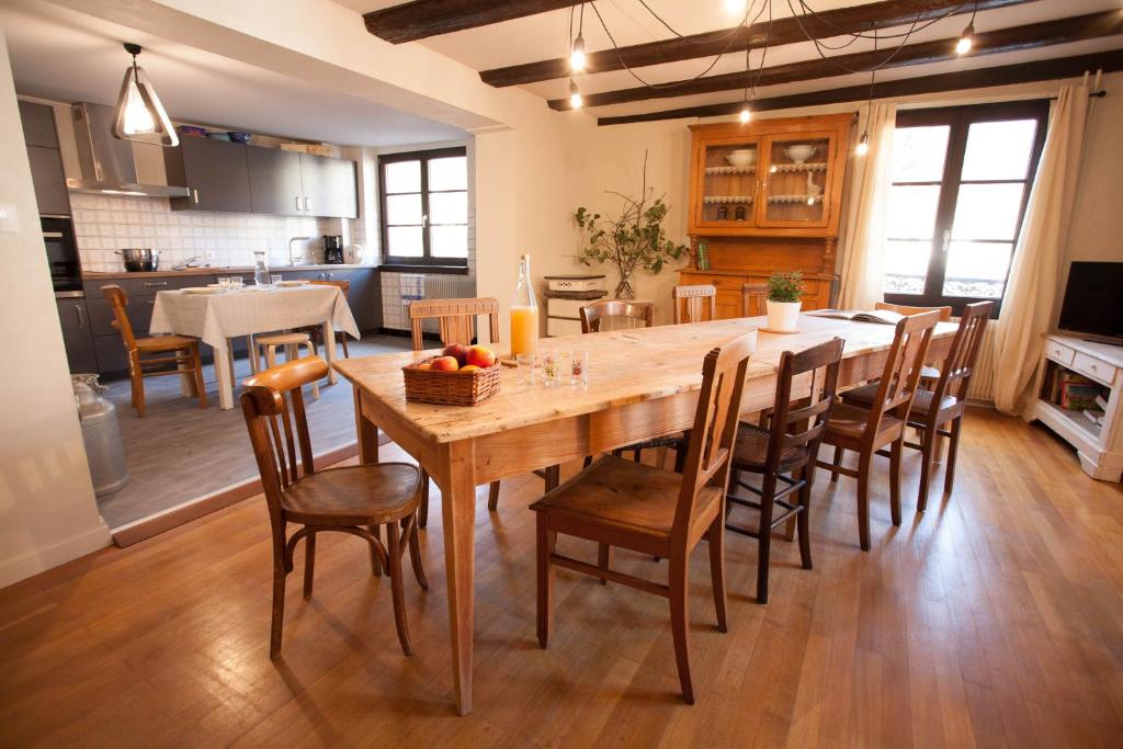 een keuken en eetkamer met een houten tafel en stoelen bij Gîte L'Atelier in Kaysersberg