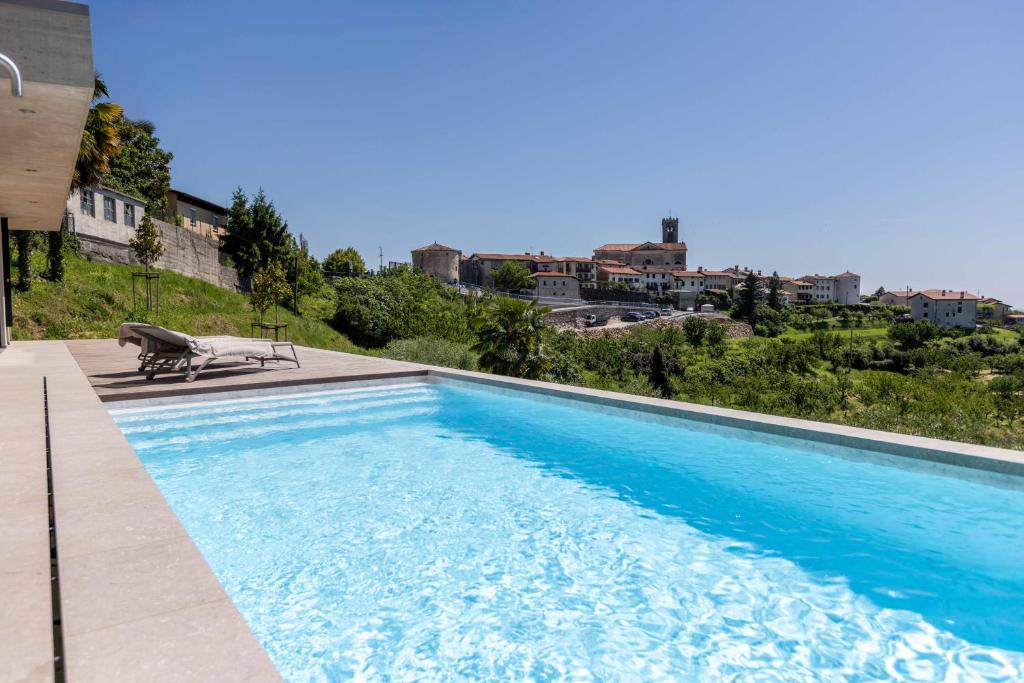 a blue swimming pool with a bench next to a building at Persolis luxury sun residence in Kojsko