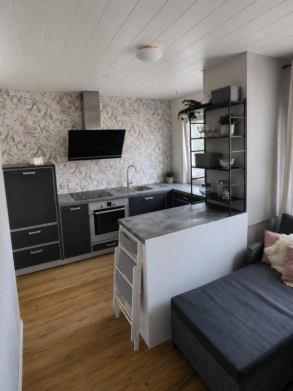 a kitchen with a counter and a couch in a room at Ferienwohnung Margarethe in Stedesdorf