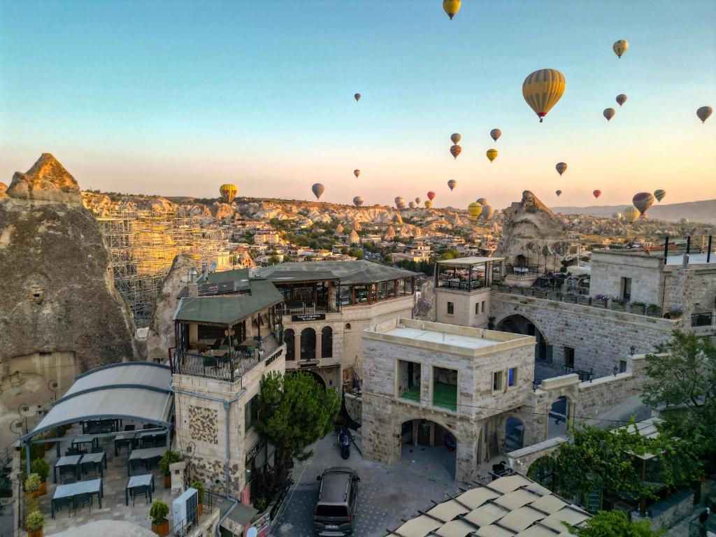 a group of hot air balloons flying over a city at Ascension Cave Suites - Special Class in Göreme