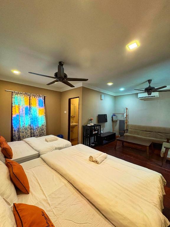 a bedroom with three beds and a couch at Rivora Gopeng in Gopeng