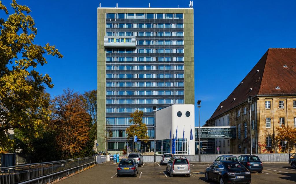 a large building with cars parked in a parking lot at Sunday Hotel Kassel in Kassel