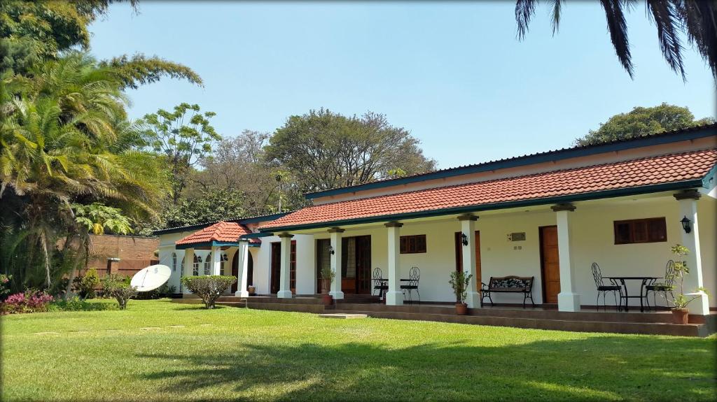 a house with a garden and a grass yard at Tranquilo Resorts Lilongwe in Lilongwe