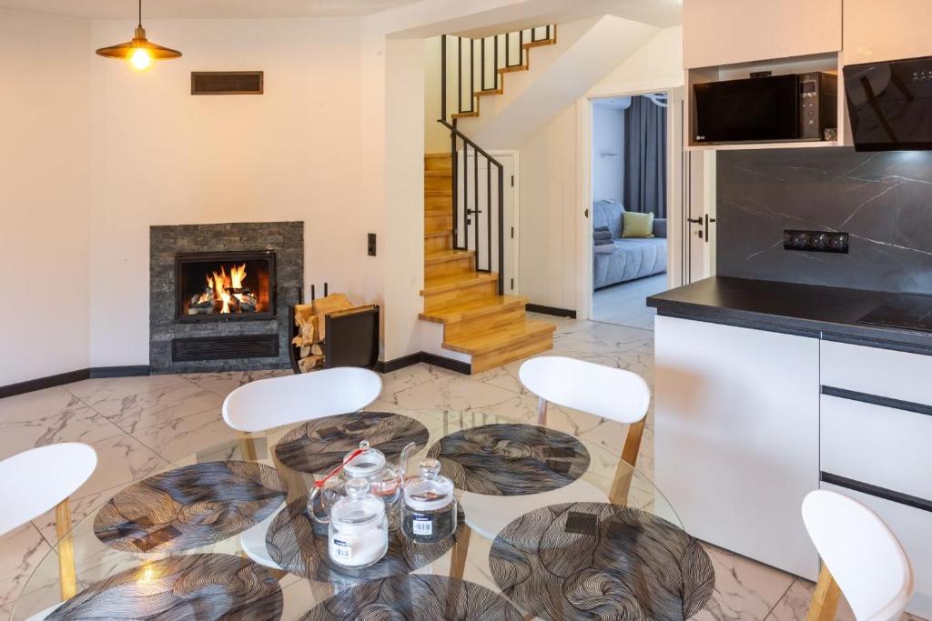 a living room with a table and chairs and a fireplace at Alpine in Skhidnitsa