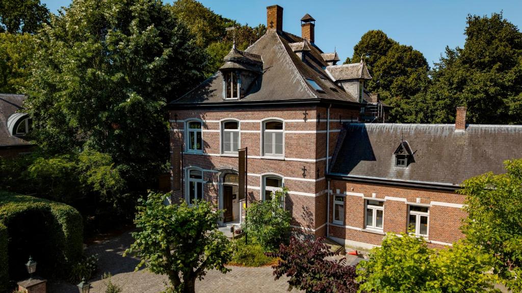 an old brick house with a roof at Boutique hotel Roosendaelhof in Geel