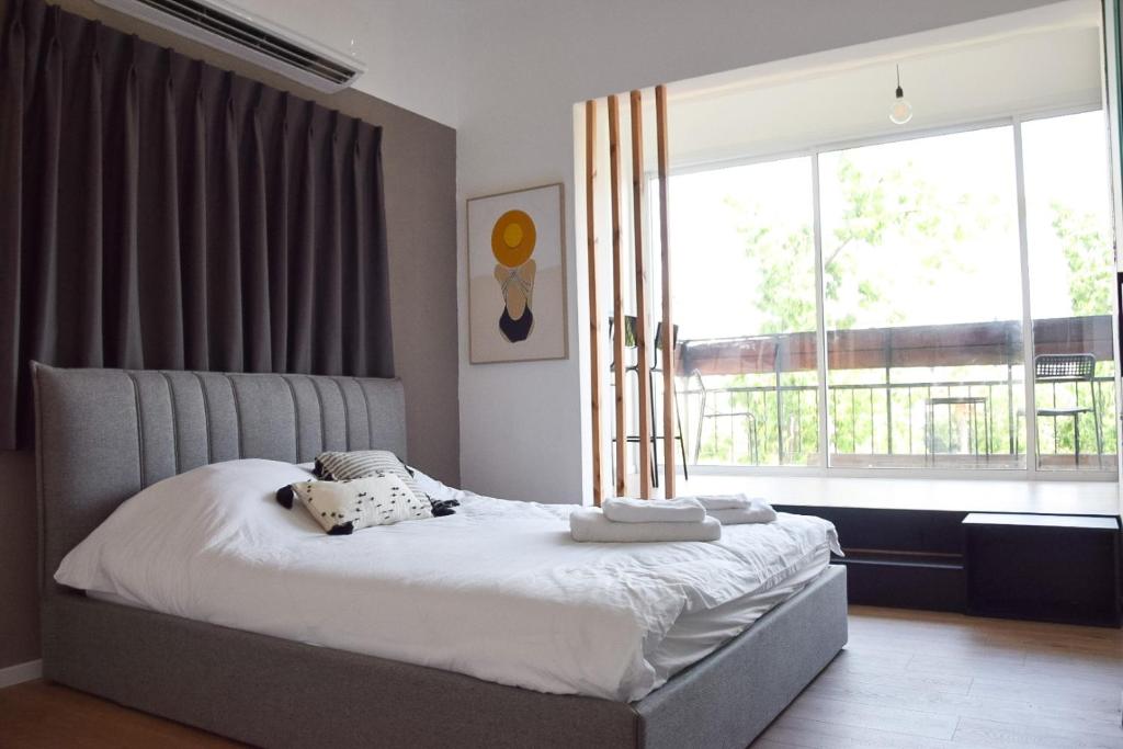 a bedroom with a bed and a large window at L7 Urban Studios in Tel Aviv