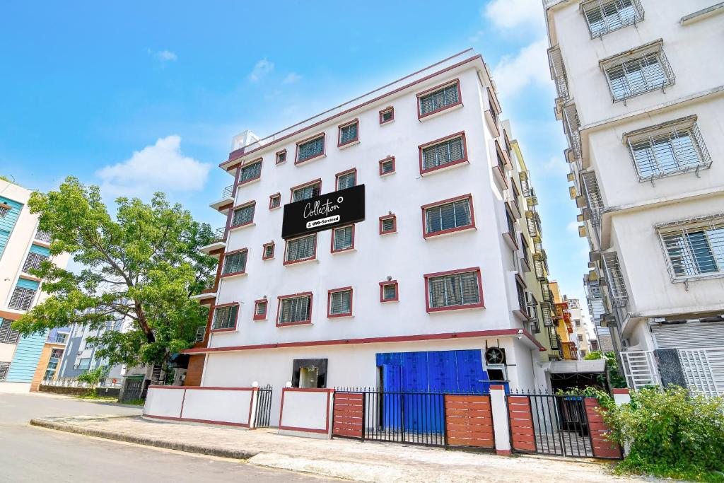 a white building with a sign on it at Super Collection O Newtown Bus Stand Formerly The Executive Suites in New Town