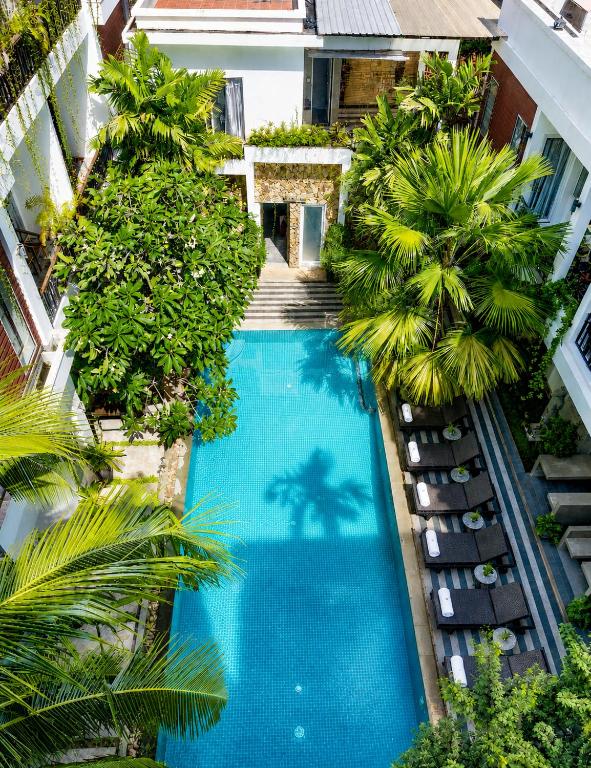 an overhead view of a swimming pool with palm trees at Boutique Indochine d'Angkor in Siem Reap