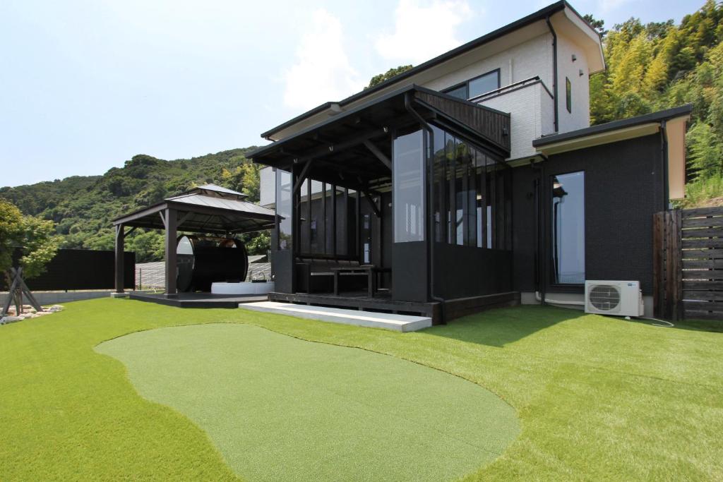 a house with a green lawn in front of it at ピッコラ カーサ コリーナ 愛犬と泊まれる貸別荘 in Awaji
