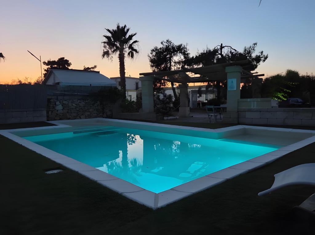 a swimming pool in a backyard with a gazebo at Masseria Prisuti in Punta Prosciutto