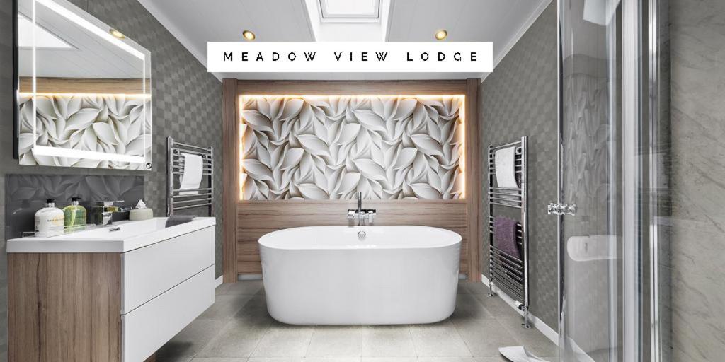 a bathroom with a white tub and a shower at Meadow View Lodge in Tattershall