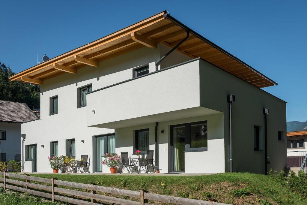 a white and green house with a wooden fence at Ferienwohnung Unterlechner - Apt 3 in Vomp