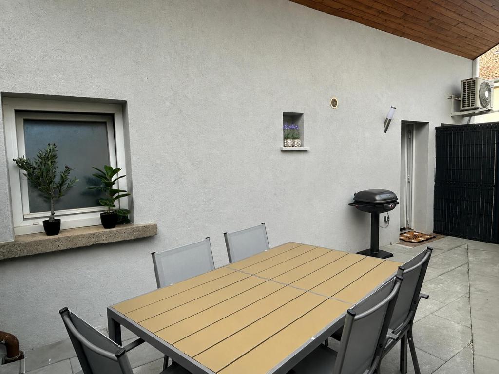a wooden table and chairs in a room at Maison indépendante Anna in Wittenheim