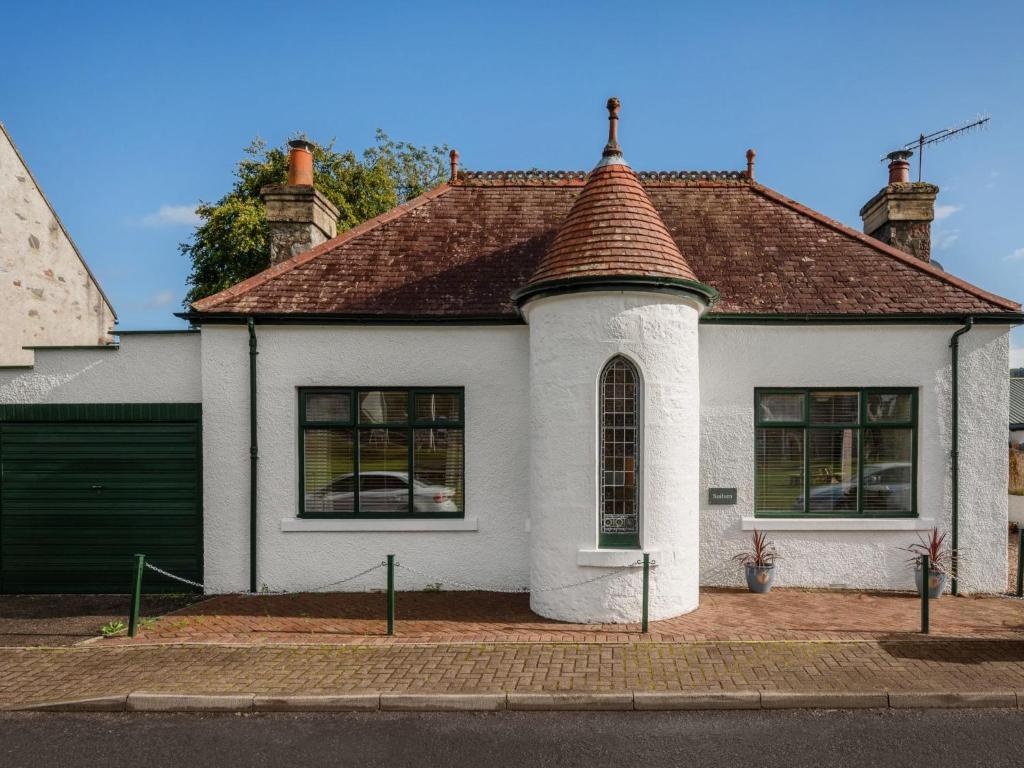 a white house with a brown roof at Holiday Home Sullivan by Interhome in Drumnadrochit