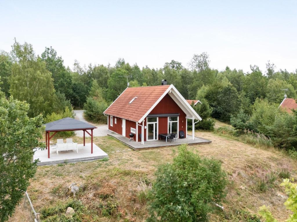 a small house with a gazebo in a field at Holiday Home Skogstorp by Interhome in Holmsjö