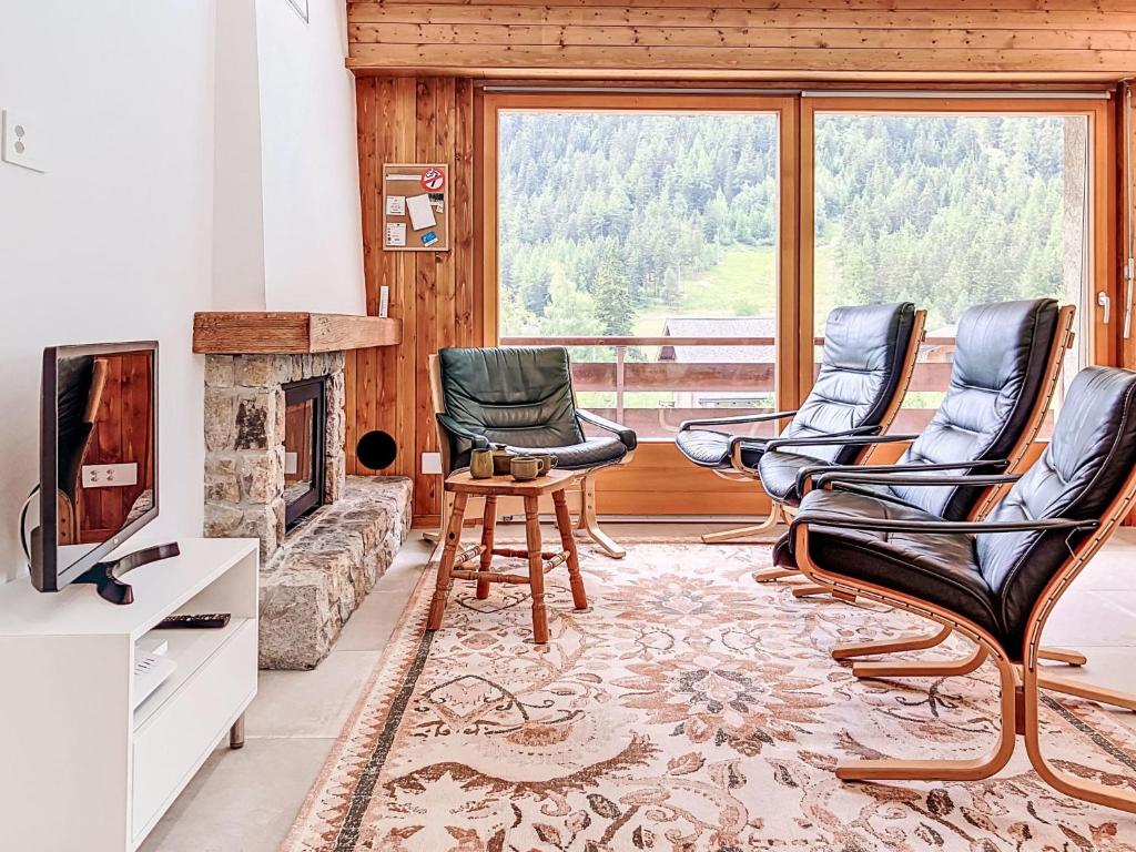 a living room with three chairs and a fireplace at Apartment Le Sporting 213 by Interhome in Champex