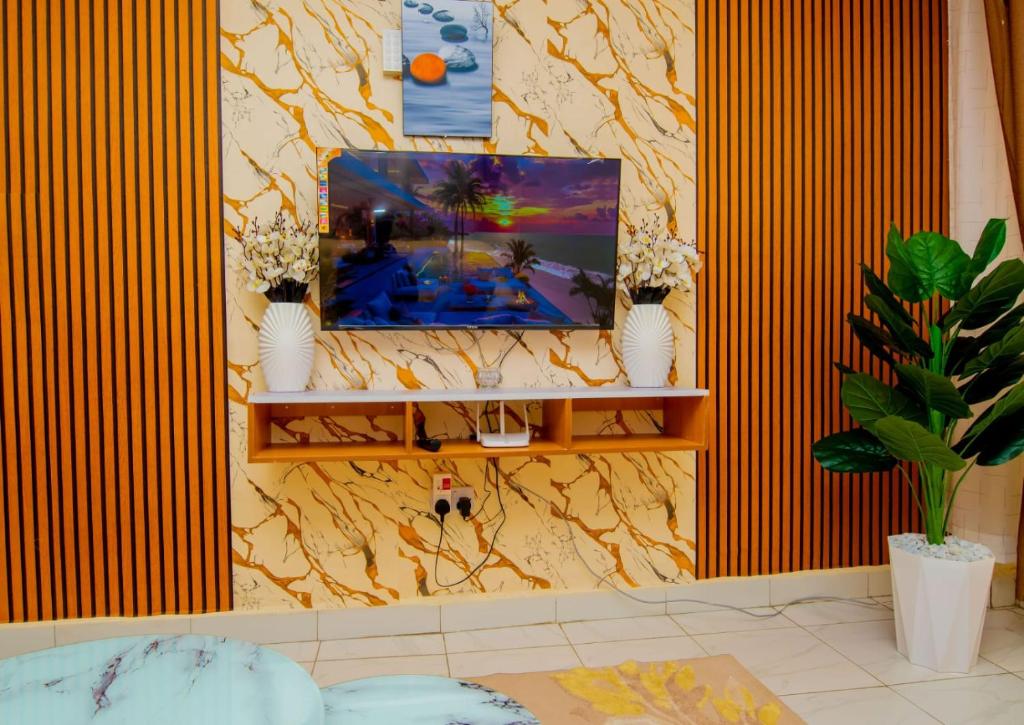 a living room with a tv on a wall at JVV Bright Suites BnB in Eldoret