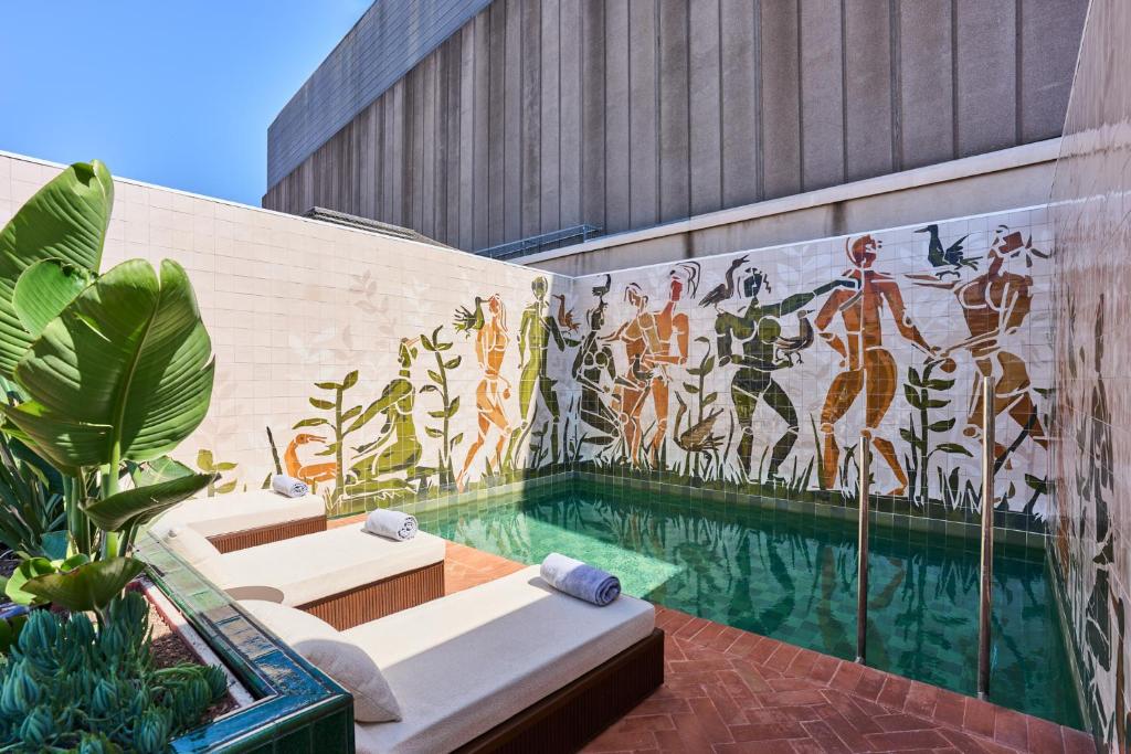 a swimming pool with a mural on the side of a building at Hotel España Ocean Drive - Newly Renovated in Barcelona