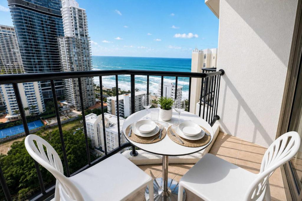 a balcony with a table and chairs and the ocean at Level 20 King Bed Suite with Ocean Views in Gold Coast