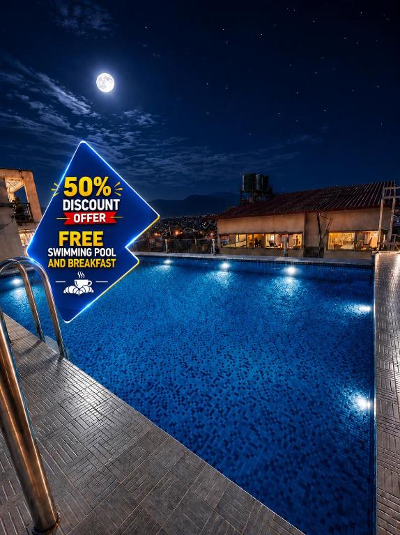 a sign next to a swimming pool at night at Beautiful Kathmandu Hotel in Kathmandu