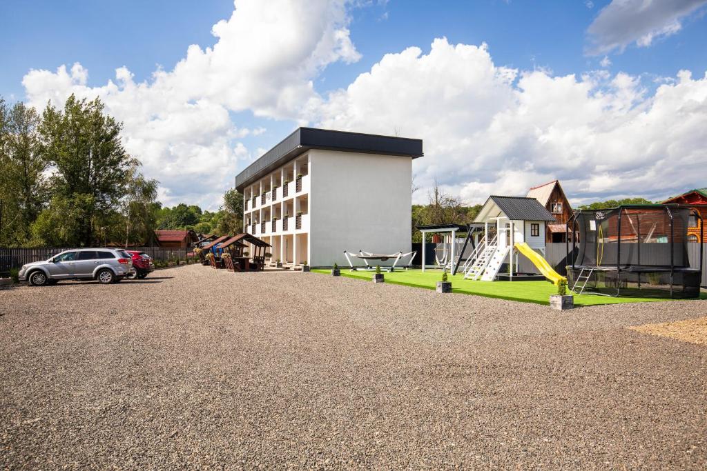 a building with a playground next to a car at Kredo in Solotvyno