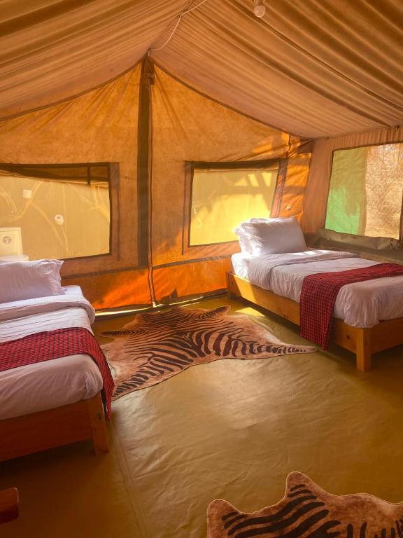 a room with two beds in a tent at Samburu Tempo Camp in Archers Post