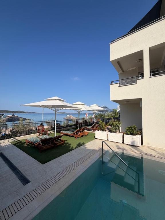a swimming pool in front of a building at Cap Adria Apartments- beachfront, private swimming pool, near Šibenik in Zaboric