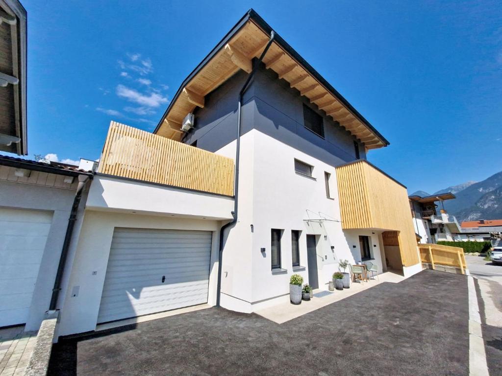 a white house with a gambrel roof at Apartment A3 by Interhome in Kematen in Tirol