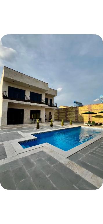 a house with a swimming pool in front of a building at Mughni home in Ashtarak