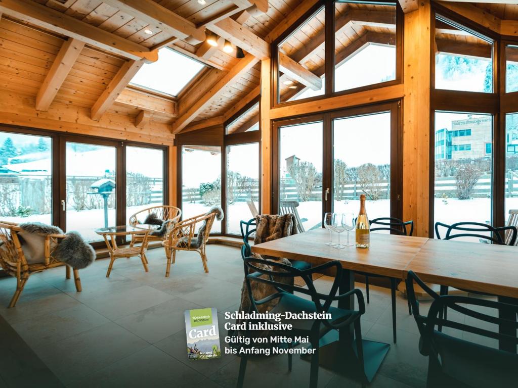 a large room with tables and chairs and windows at Haus Ennsegg by Schladming-Appartements in Haus im Ennstal