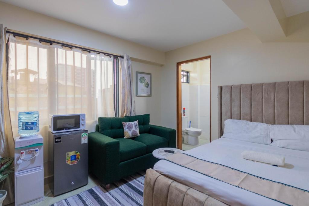a hotel room with a bed and a green chair at Caramel Studio In CBD with Free WI-FI in Nanyuki