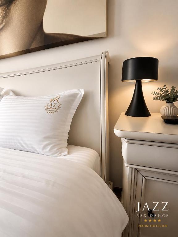 a bed with a black lamp on a side table at Jazz Residence in Piatra Neamţ