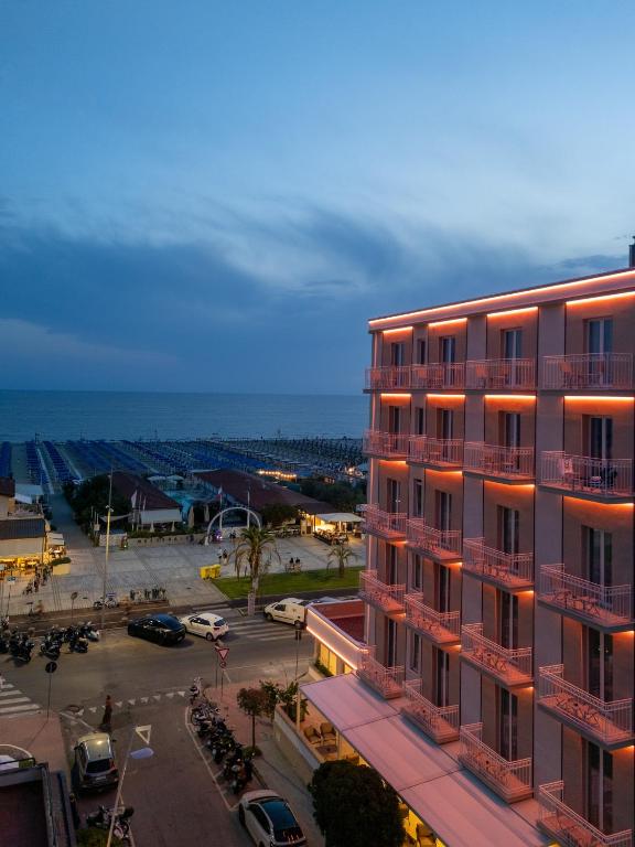 a building with a parking lot in front of the ocean at Vi Place in Lido di Camaiore