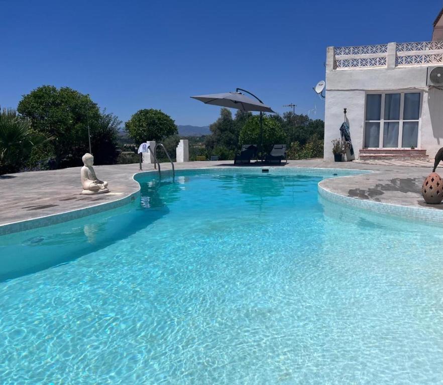 a swimming pool with blue water in front of a house at Villa Raziel in Cártama