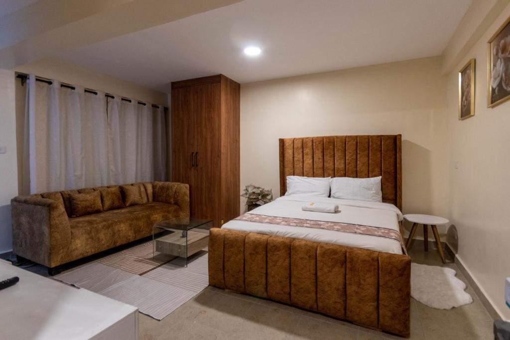a bedroom with a large bed and a couch at Rustic Studio in CBD with free WI-FI in Nanyuki