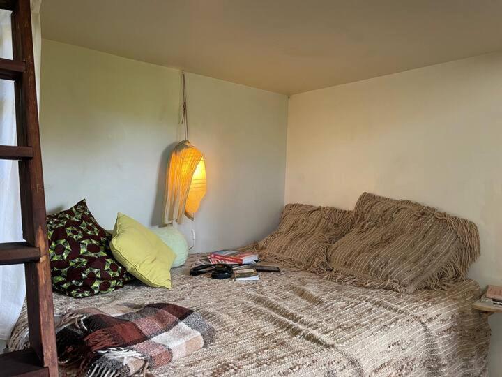 a bedroom with a bed with a blanket and a lamp at Robinson guesthouse & massages in Marseille