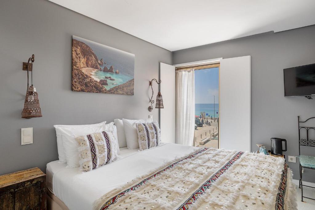 a bedroom with a bed with a view of the ocean at Casa da Praça - Alojamento Local in Sesimbra