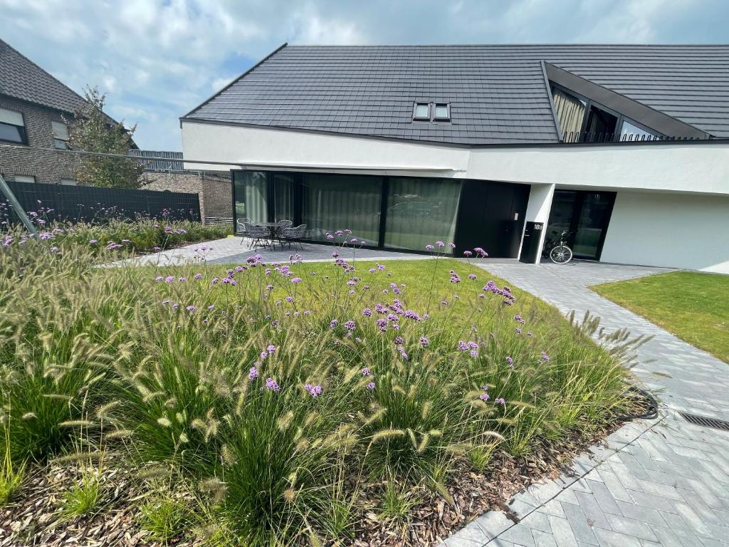 a house with a garden with purple flowers at Ferienwohnung Zwischenhoch in Kranenburg