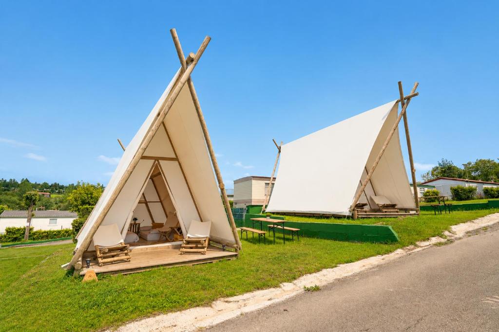 a triangular tent on the side of a road at Kampaoh Oyambre in El Tejo