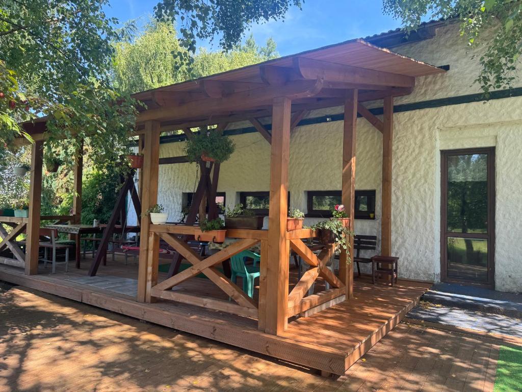 a wooden pavilion with a table on a patio at Agroturystyka Kociewiak in Szteklin