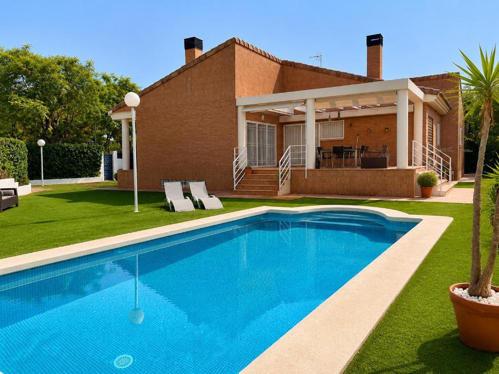 a swimming pool in front of a house at Villa La Perla - Pool, Garden & Barbecue - AC in Mutxamel