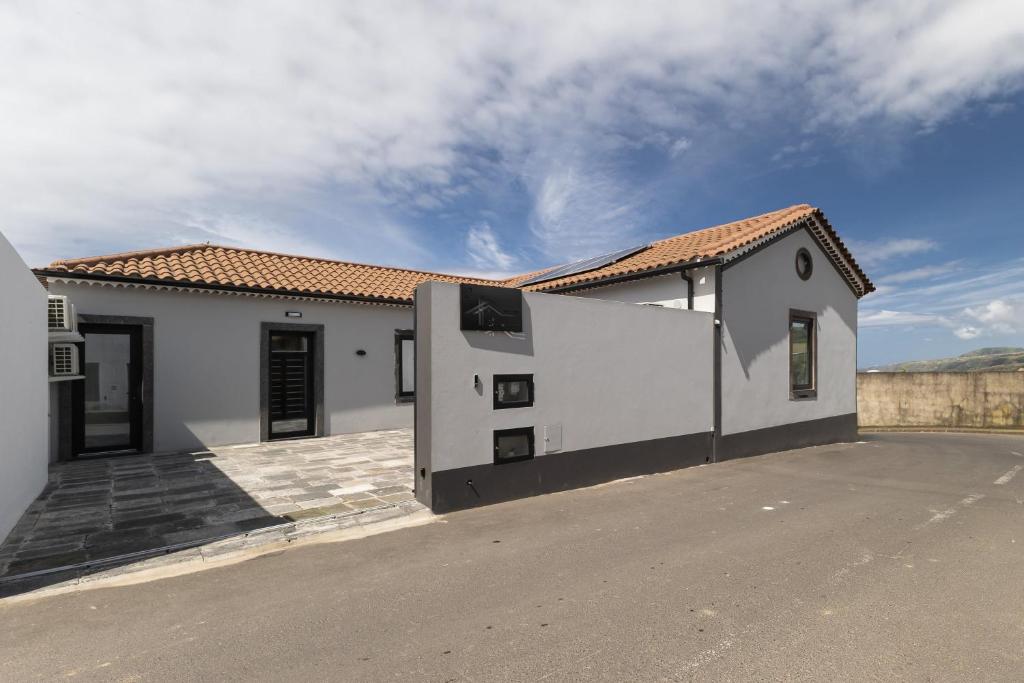 a white house with a driveway in front of it at Casa da eira in Ribeira Grande