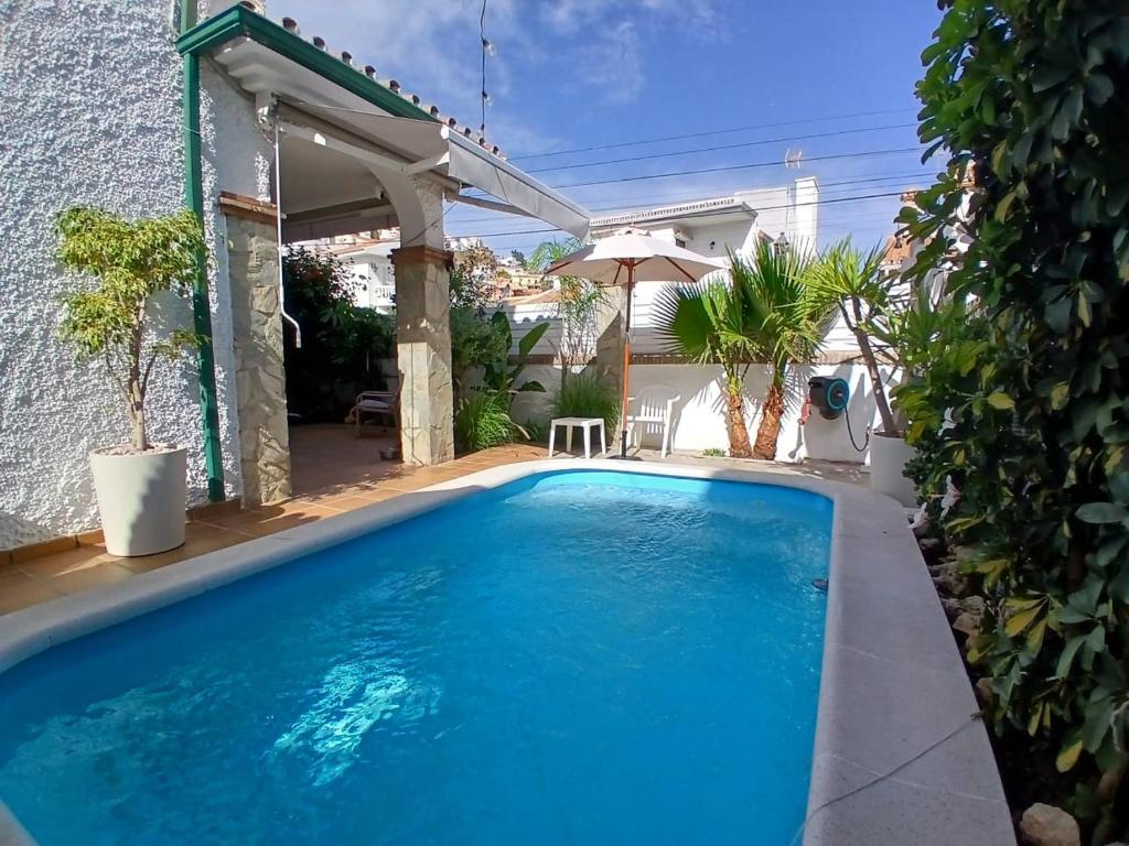 a swimming pool in front of a house at Casa Lunamar in Rincón de la Victoria