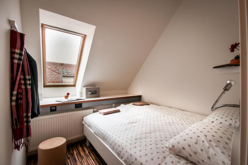 a small bedroom with a bed and a window at CUBE central rooms for 2 in Ljubljana